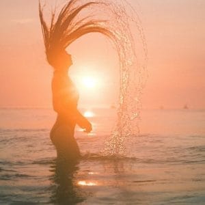 woman in the ocean at sunset
