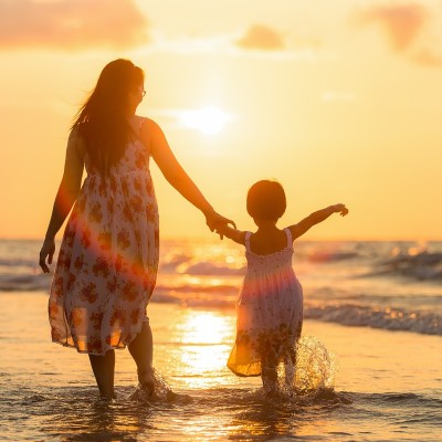 Mother and child at a scuba diving resort beach at sunset