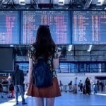 Woman looking at arrivals and departures board in airport