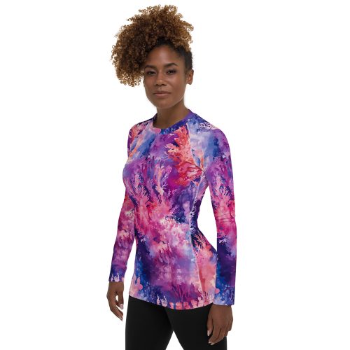 Woman facing the camera, wearing coral reef print rash guard.