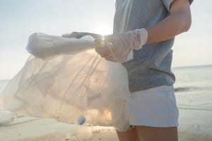 A person participating in a beach cleanup.