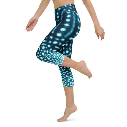 Model with one leg up, wearing whale shark capri leggings.